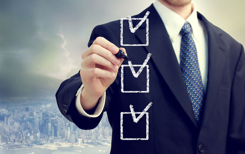 O plano de marketing deve definir metas na sua empresa. A imagem mostra um homem de negócios usando um checklist virtual.