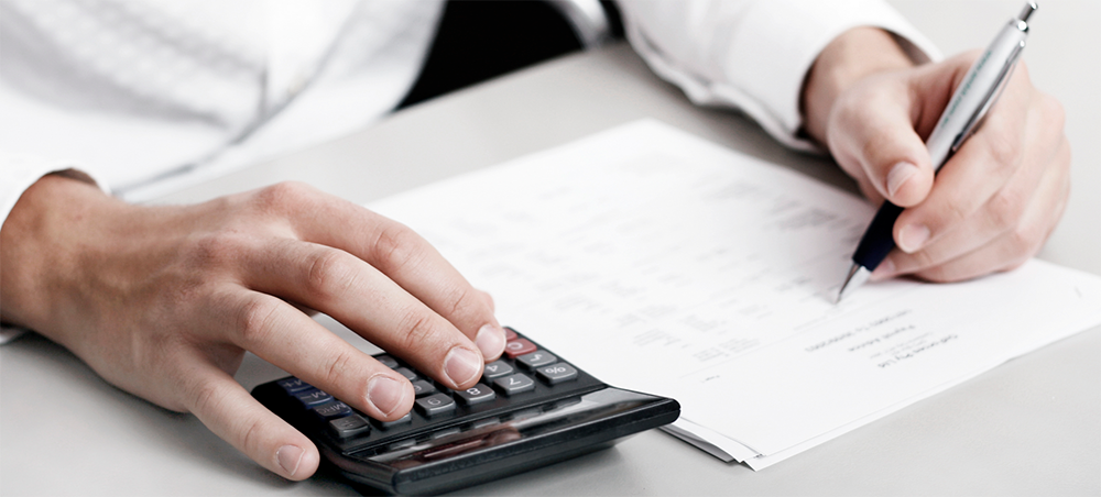 Fórmula do Ponto de Equilíbrio. A imagem mostra uma pessoa fazendo cálculos com a ajuda de uma calculadora.
